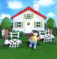 a girl is sitting on a lawn with cows and a house